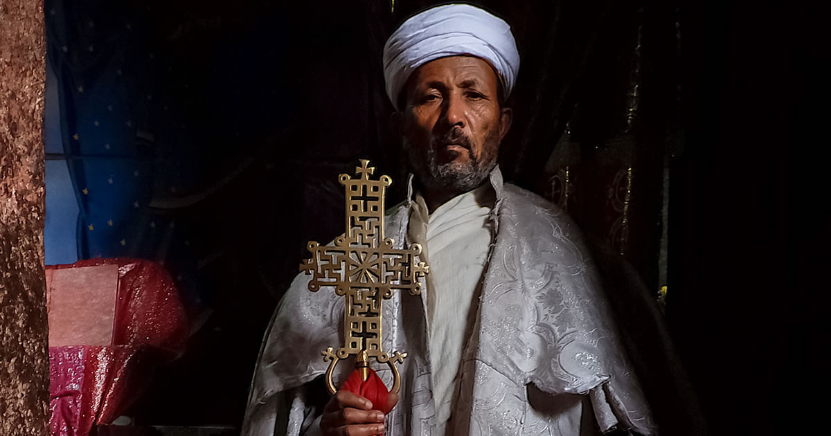 An Ethiopian Christian Priest Holding a Bronze Cross Featured